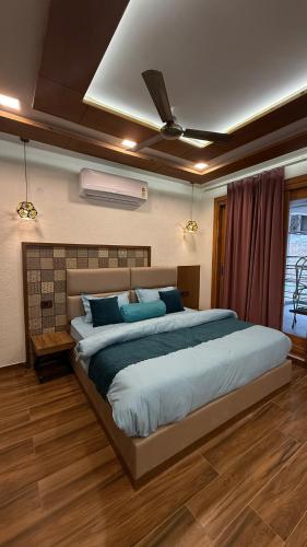 a bedroom with a large bed with blue pillows at Yes Hotel By The Ganges in Rishīkesh