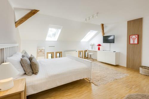 a white bedroom with a large bed and a television at Gasthaus Landbrecht in Freising