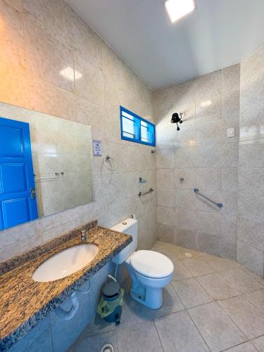 a bathroom with a toilet and a sink and a mirror at Hotel Paraiso Maragogi LTDA in Maragogi