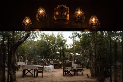 a restaurant with tables and chairs and lights at Maroelani Lodge- Greater Kruger Private Reserve in Hoedspruit
