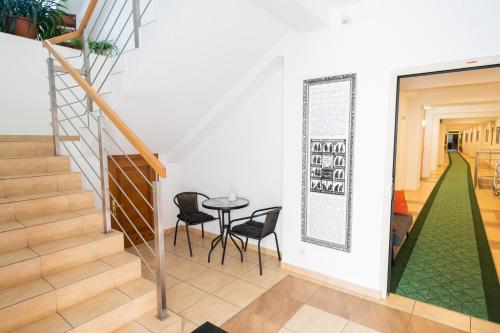 a staircase with a table and chairs in a room at Pokoje Gościnne Dom św. Szymona in Kraków