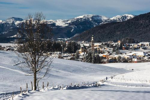 a snow covered hill with a town in the distance at Il Fauno in Asiago