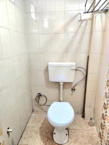 a bathroom with a white toilet in a room at BITS CAMPUs in Varanasi
