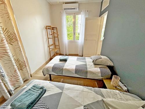 une chambre avec deux lits et une fenêtre dans l'établissement Gite Grand Chantilly -Maison 2CHB-2SDB 6p & Studio 2p, à Châteauroux