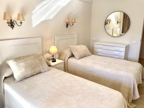 dwa łóżka w pokoju z lustrem w obiekcie Relax y Confort, Apartamento Reformado con Piscina w mieście Benidorm