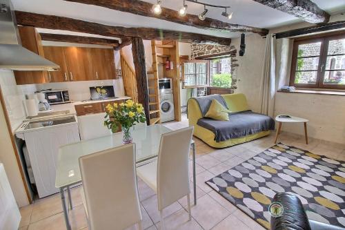 une cuisine et un salon avec une table et un canapé dans l'établissement Stable cottage, à Pleudihen-sur-Rance