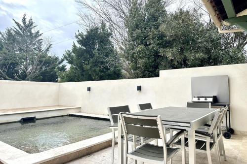 un patio avec une table et des chaises à côté d'une piscine dans l'établissement Villa Keromate air-conditioned with natural pool, à Entraigues-sur-la-Sorgue