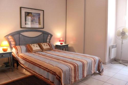 - une chambre avec un grand lit et une couverture rayée dans l'établissement SP480-191 Mais 2 pièces mezzanine SAINT PIERRE LA MER, à Saint Pierre La Mer