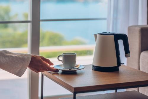 a person holding a cup of coffee on a table at Iberostar Selection Jardín del Sol Suites - Adults Only in Santa Ponsa