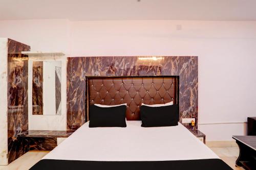 a bedroom with a large bed with a large headboard at Hotel O Payal Guest House in Baharampur