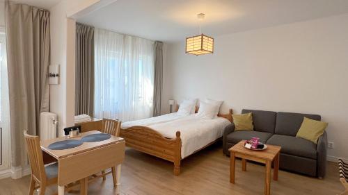 a bedroom with a bed and a couch and a table at Charming City Studio, 10 Min Walk to Train Station in Stockholm