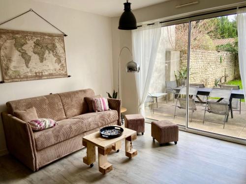 un salon avec un canapé et une table dans l'établissement Appartement cosy avec jardin proche centre ., à La Rochelle
