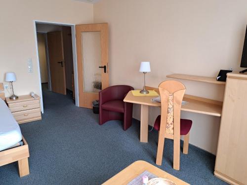 a hotel room with a table and a chair at Hotel Heikenberg in Bad Lauterberg