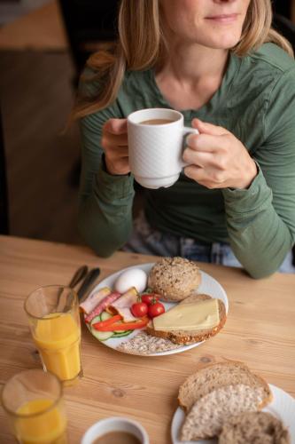 Sør-FronにあるDale-Gudbrands Gard by Frich`sの食べ物の皿を持ってテーブルに座っている女性