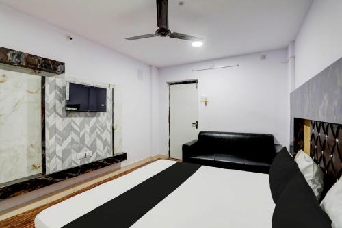 a bedroom with a bed and a black couch at Hotel O Payal Guest House in Baharampur