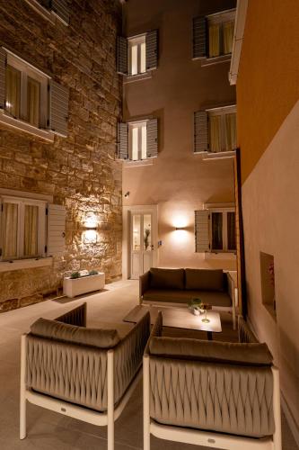a large living room with couches and a stone wall at Olea Luxury Rooms & Spa in Split