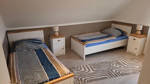 a bedroom with two beds and two rugs at Ferienwohnung Lampe in Altenberge