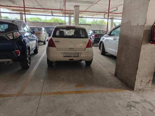 a small white car parked in a parking lot at Modern 3BHK with fully equipped kitchen on 15Floor only for families in Bengaluru