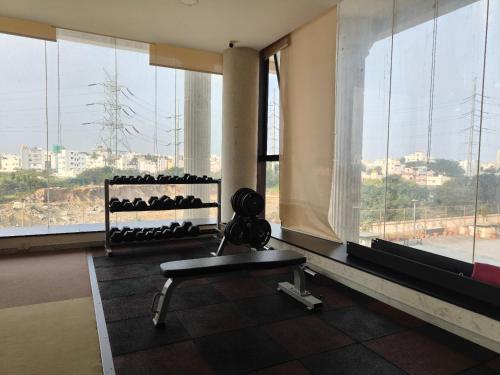 a gym with a bench in front of a window at Modern 3BHK with fully equipped kitchen on 15Floor only for families in Bengaluru