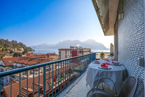 a table on a balcony with a view of a city at L’Attico di Susanna in Verbania