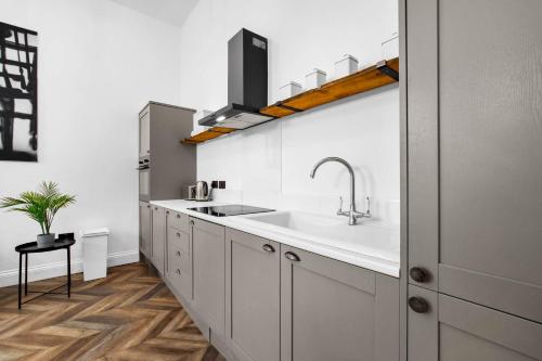 a kitchen with white cabinets and a sink at Stylish 2 Bedroom Apartment - Netflix - Wolverhampton Centre - 2TO in Wolverhampton