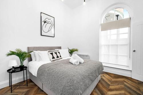 a white bedroom with a bed and a window at Stylish 2 Bedroom Apartment - Free WiFi - Netflix - Wolverhampton Centre - 2TO in Wolverhampton