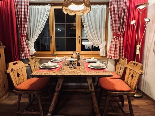 a dining room table with chairs and a window at Gstaad Central and View in Gstaad