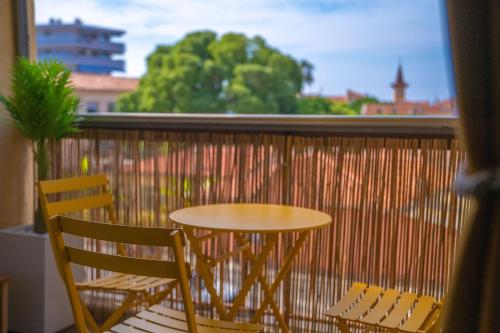 une table et des chaises sur un balcon avec une fenêtre dans l'établissement Cros Studio – Cozy Stay Near the Beach, à Cagnes-sur-Mer