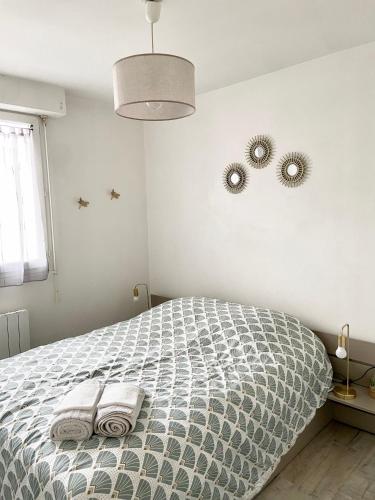 une chambre avec un lit avec deux serviettes dessus dans l'établissement Appartement cosy avec jardin proche centre ., à La Rochelle