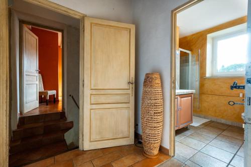 une chambre avec une porte et un vase au sol dans l'établissement Mas des Cyprès, à La Bâtie-Rolland