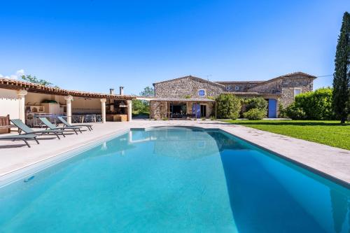 une image d'une piscine en face d'une maison dans l'établissement Mas des Cyprès, à La Bâtie-Rolland