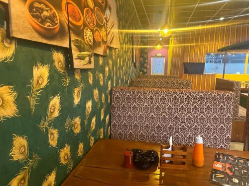 a dining room with a table and a wall with flowers at Yaa Beach in Trincomalee