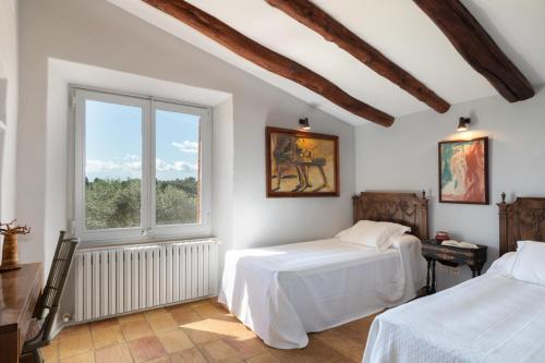 a bedroom with two beds and a window at Exquisite farmhouse in the Empordà Costa Brava in Vall-Llobrega