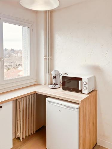 un micro-ondes posé sur un comptoir dans une cuisine dans l'établissement La pupille de la nation d'Aurillac, 4 pers, à Aurillac