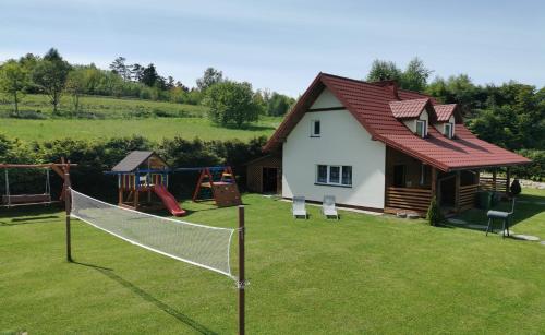 a house with a net in the yard at Bieszczady111 - domki in Polańczyk