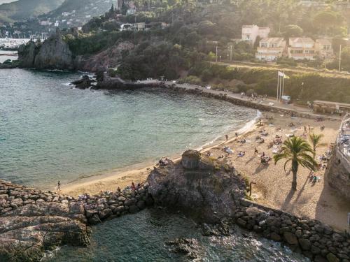 une plage avec un groupe de personnes sur la plage dans l'établissement Terrasses sur La Mer – Amazing Sea Views, à Mandelieu-la-Napoule