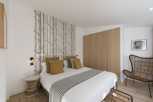 une chambre avec un grand lit blanc et une chaise dans l'établissement Yacht, à Paris