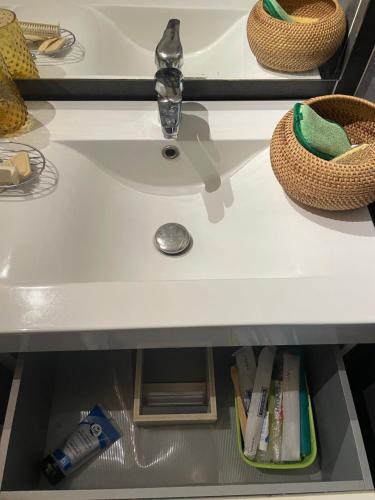 a bathroom sink with a faucet and books at Chambre lit double à 3 mins à pied du Lagon Salines les bains in La Saline les Bains