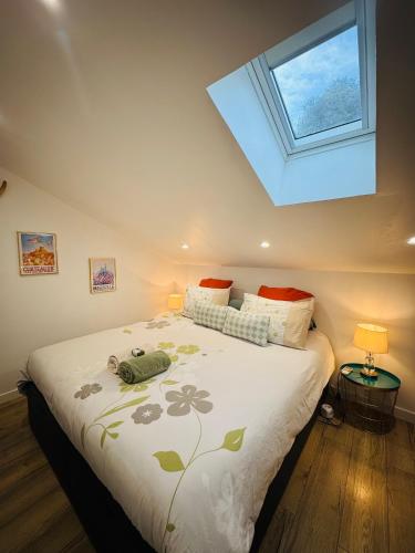 une chambre avec un grand lit avec une lucarne dans l'établissement Les nuits d'été Niolon, à Le Rove