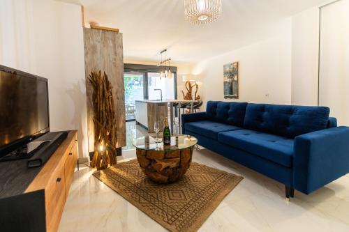 un salon avec un canapé bleu et une télévision dans l'établissement Appt 4 étoiles, T3 Neuf et chic à Bonifacio, à Bonifacio