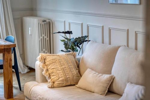 - un canapé blanc avec un oreiller dans le salon dans l'établissement #HS The precious Paul Mistral, à Grenoble