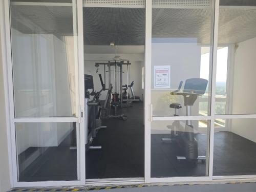 a gym with glass doors and exercising equipment in it at Luxury Beachfront Apartment in Bopitiya