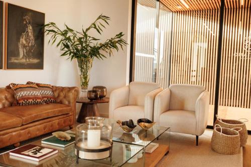 a living room with a couch and two chairs and a table at Lusitano Garden Villas in Ponta Delgada