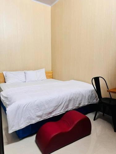 a bedroom with a bed with a red ottoman on the floor at Vinh Hotel in Thốt Nốt