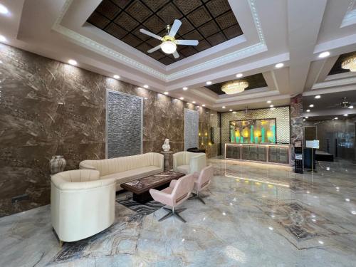 a lobby with a couch and chairs and a ceiling at Outstay Executive Apartments in Navi Mumbai