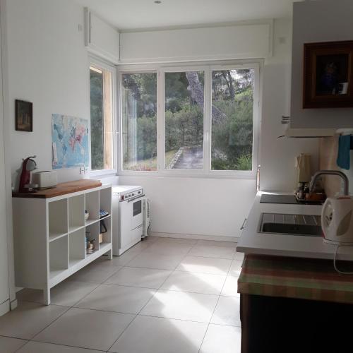 une cuisine avec des appareils blancs et une grande fenêtre dans l'établissement Villa Nicole avec Spa professionnel, à Carry-le-Rouet