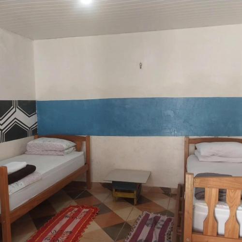 a small room with two beds and a table at Quarto compartilhado com ar condicionado banheiro externo compartilhado in Alter do Chao