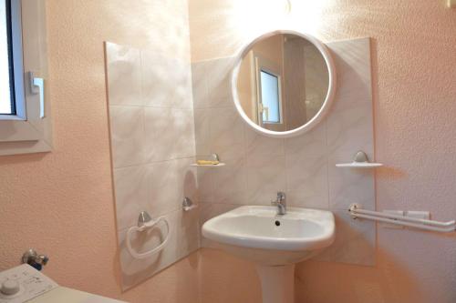 une salle de bain avec un lavabo et un miroir dans l'établissement SP000-04B Maison 3 pièces SAINT PIERRE LA MER, à Saint Pierre La Mer