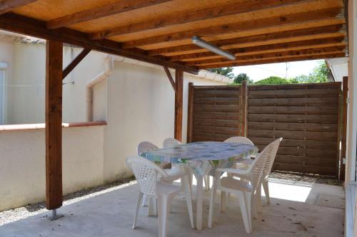 une table et des chaises assises sous une pergola dans l'établissement SP000-04B Maison 3 pièces SAINT PIERRE LA MER, à Saint Pierre La Mer