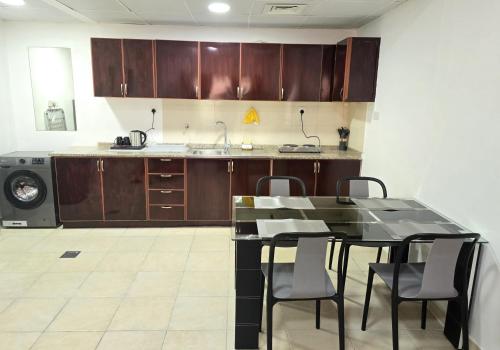 a kitchen with a table and chairs and a washing machine at Luxury 1-Bedroom Suite Near All Amenities in Abu Dhabi